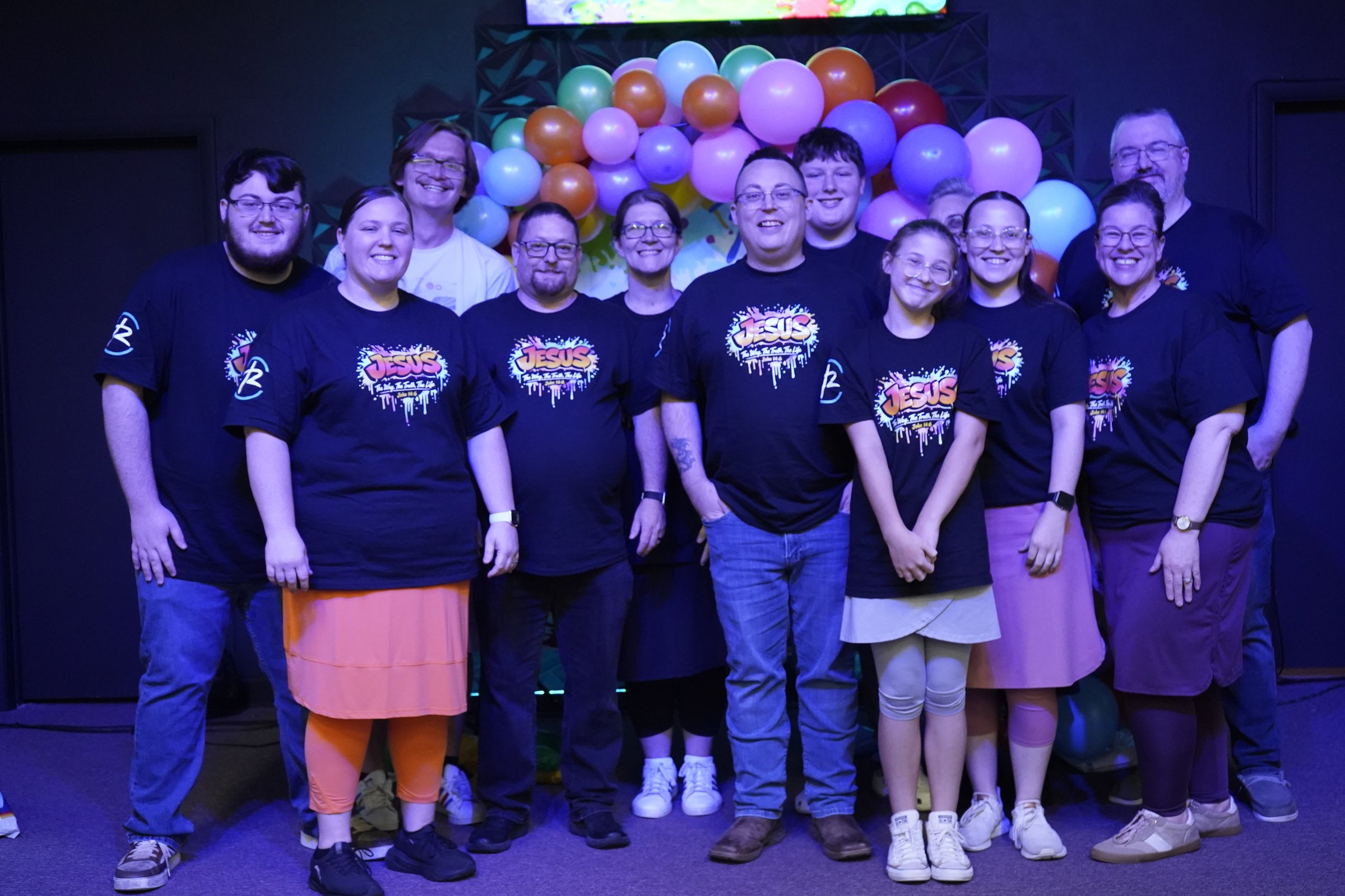 Refuge Church members gathered together in front of colorful balloons
